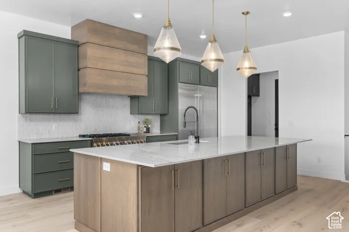 Central island with a light-toned countertop, wood-finish base cabinetry, and pendant lighting