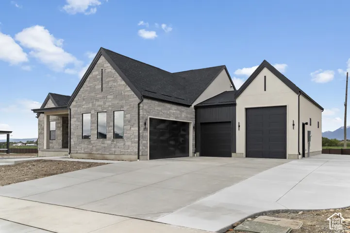 Stone veneer and stucco exterior with dark trim accents
