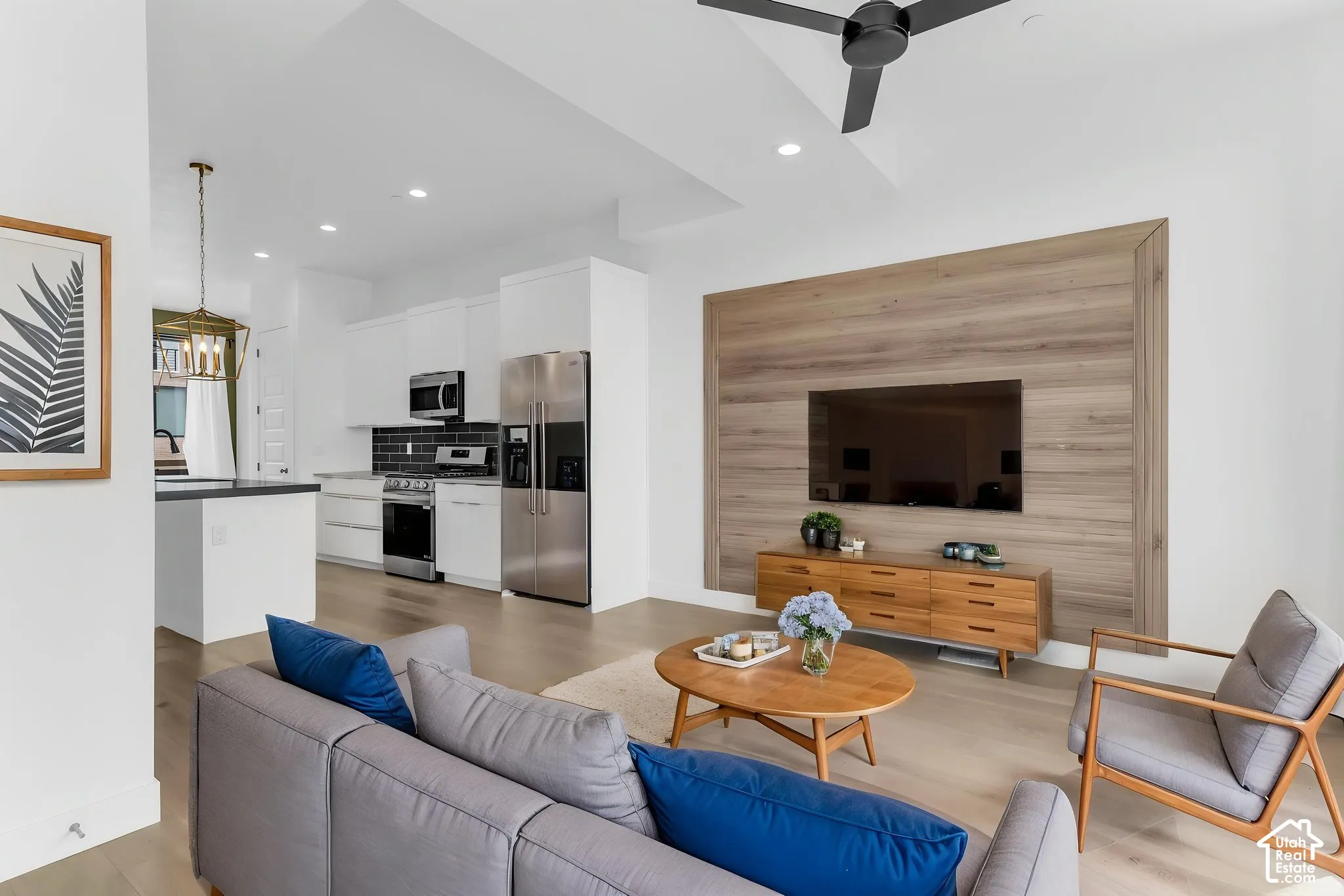 AI Staged. Open-concept living space featuring wood-finish flooring, a contemporary ceiling fan, and recessed lighting