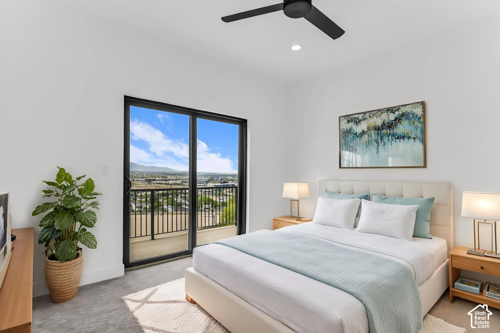 Sliding glass door opening to a private balcony with metal railings, recessed lighting, and a ceiling fan