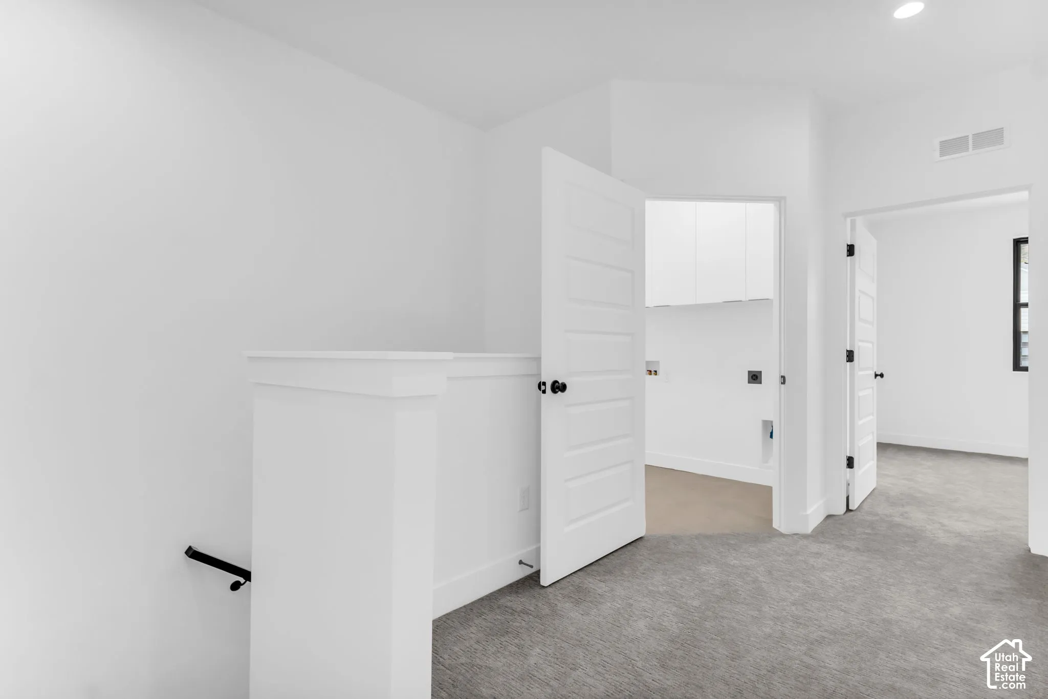Crisp white walls, modern panel doors with matte black hardware, and recessed lighting