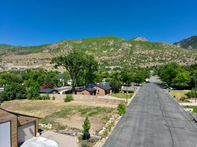 Expansive lot featuring a newly constructed detached garage with wood-look siding, a concrete driveway, and a gravel pathway
