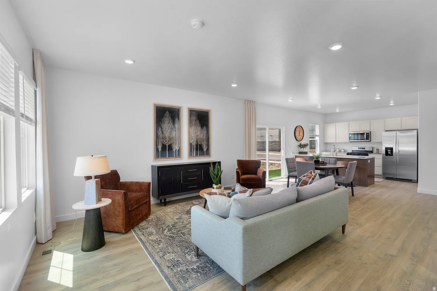 Open-concept living space featuring wood-finish flooring, recessed lighting, and white walls