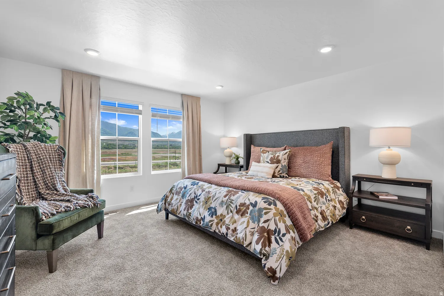 Plush carpeting, recessed lighting, and a textured headboard define this space