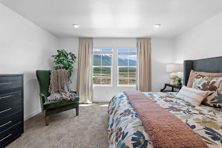 Recessed lighting, soft gray carpeting, and white walls with a mountain backdrop