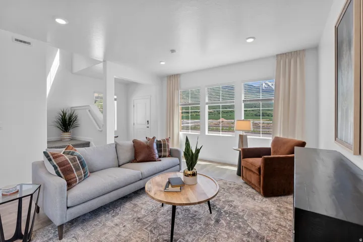 Open-concept living area featuring light wood-finish flooring, recessed lighting, and large windows with mountain scenery
