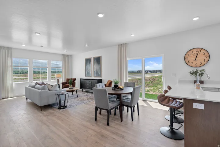 Open-concept living space featuring wood-finish flooring, recessed lighting, and a sliding glass door