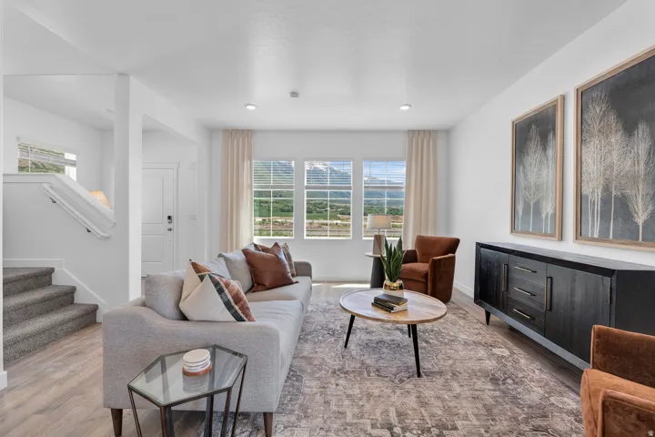 Spacious living area featuring wood-finish flooring, recessed lighting, and multiple windows with mountain scenery