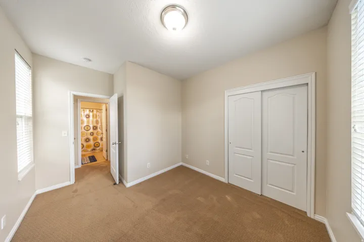 Plush carpeted flooring, a ceiling-mounted light fixture, and white trim throughout