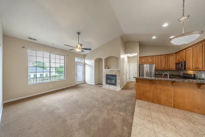Vaulted ceilings, large windows, and a stone-surround fireplace