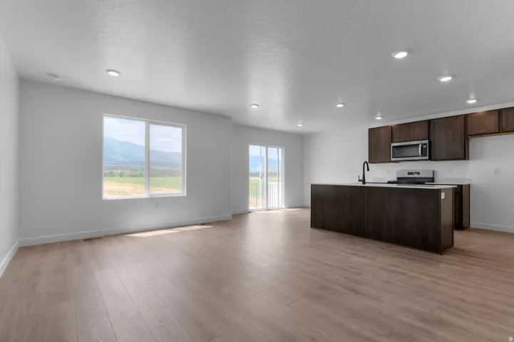 Open-concept living space featuring wood-finish flooring, recessed lighting, and white walls