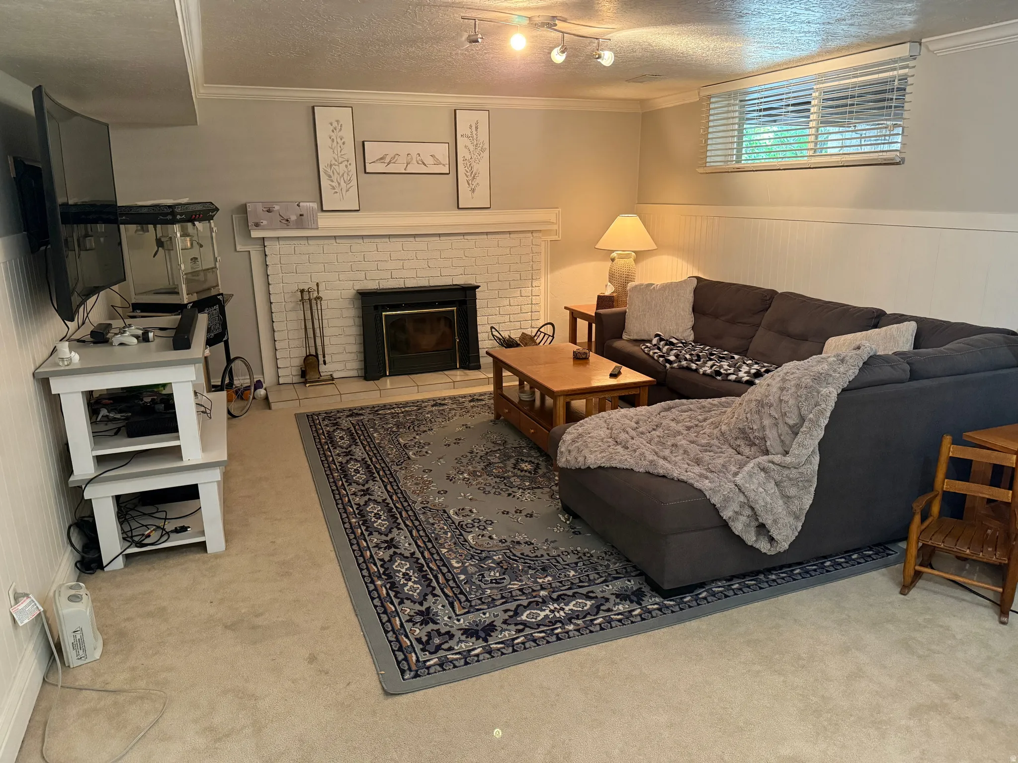 White brick fireplace with a black firebox, white mantel, and crown molding