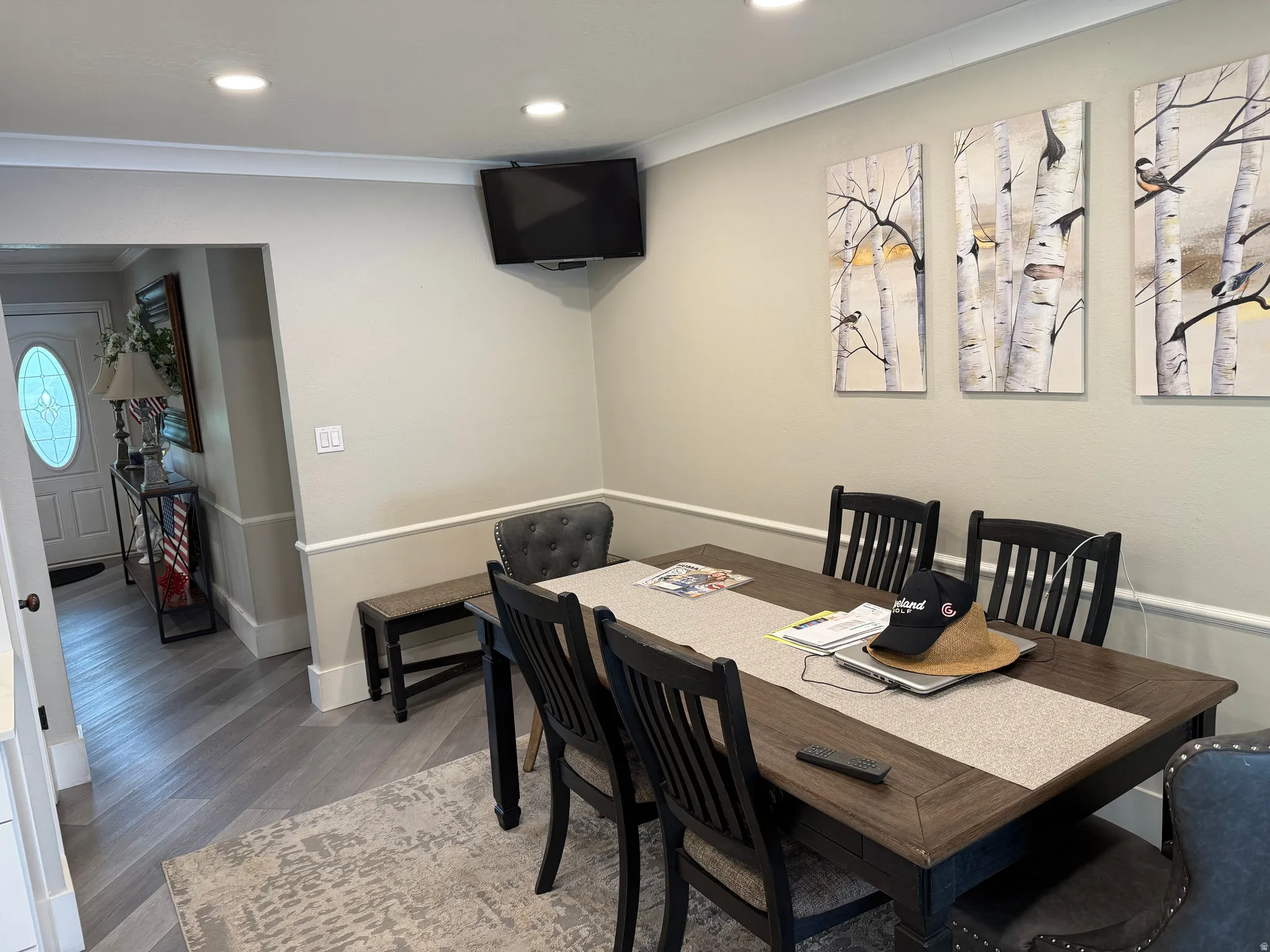 Recessed lighting illuminates the dining space featuring crown molding and chair rail detailing