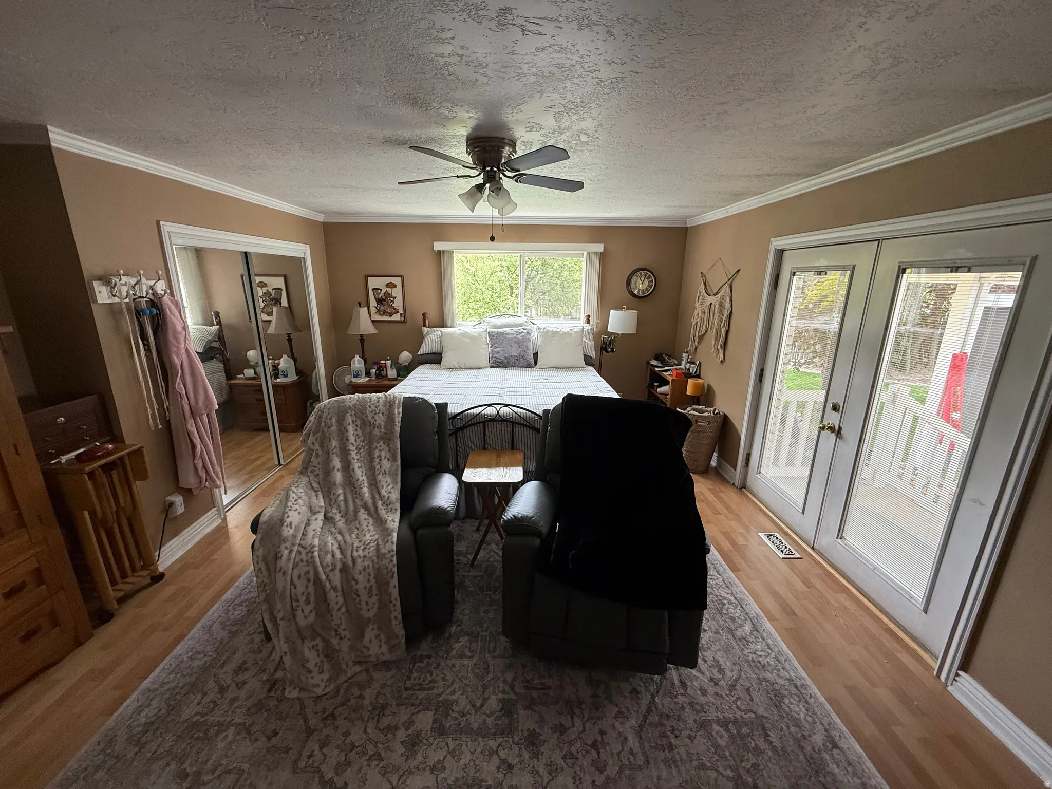 Wood-finish flooring, crown molding, and a ceiling fan are featured