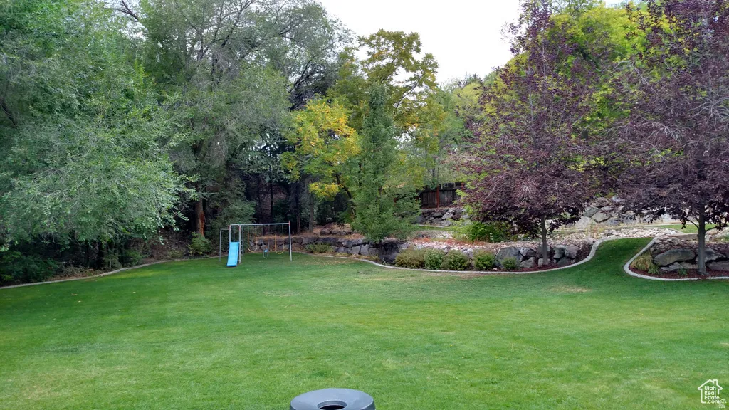 Expansive lawn area with mature trees and landscaped rock garden beds
