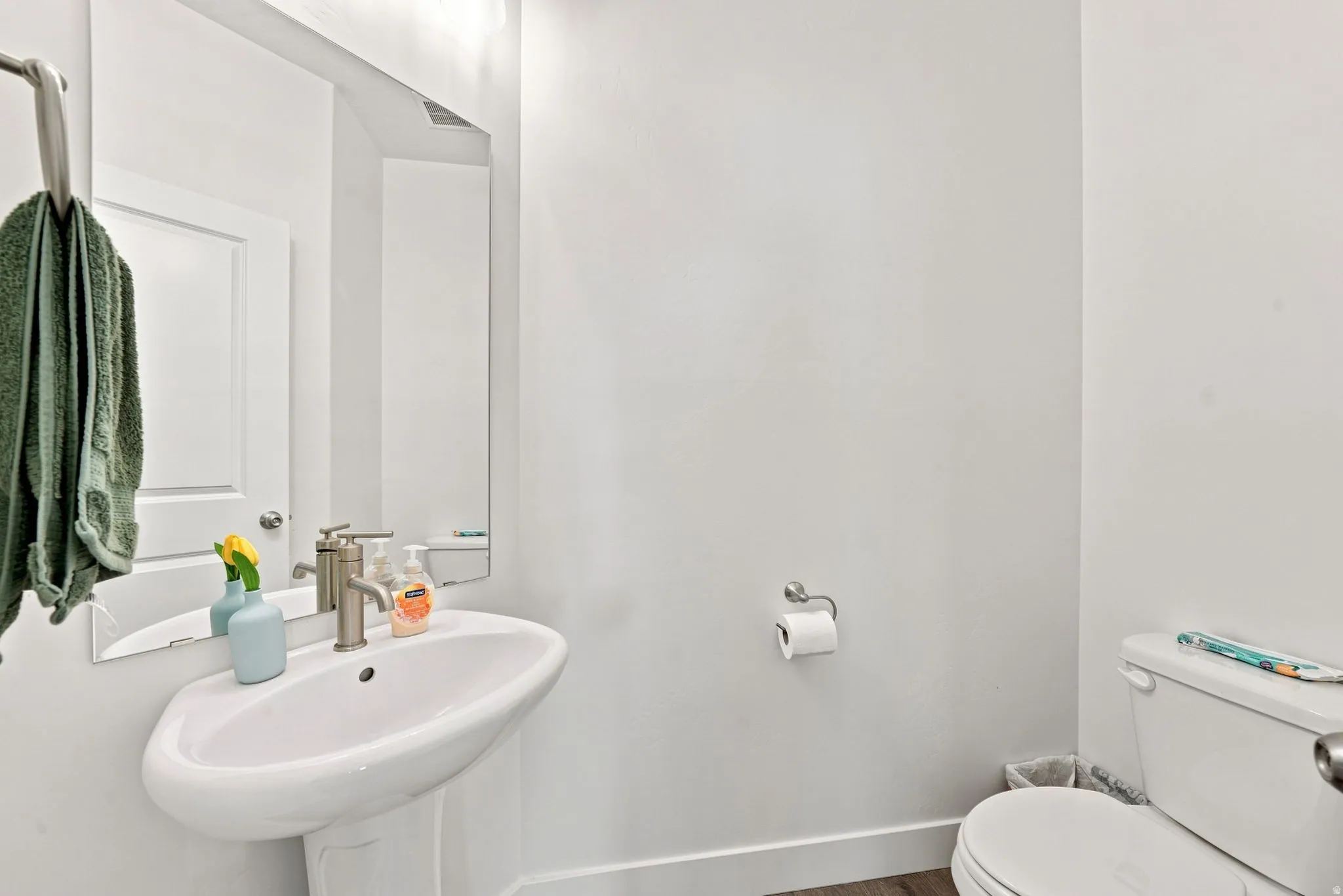 Pedestal sink with a single-handle brushed nickel faucet