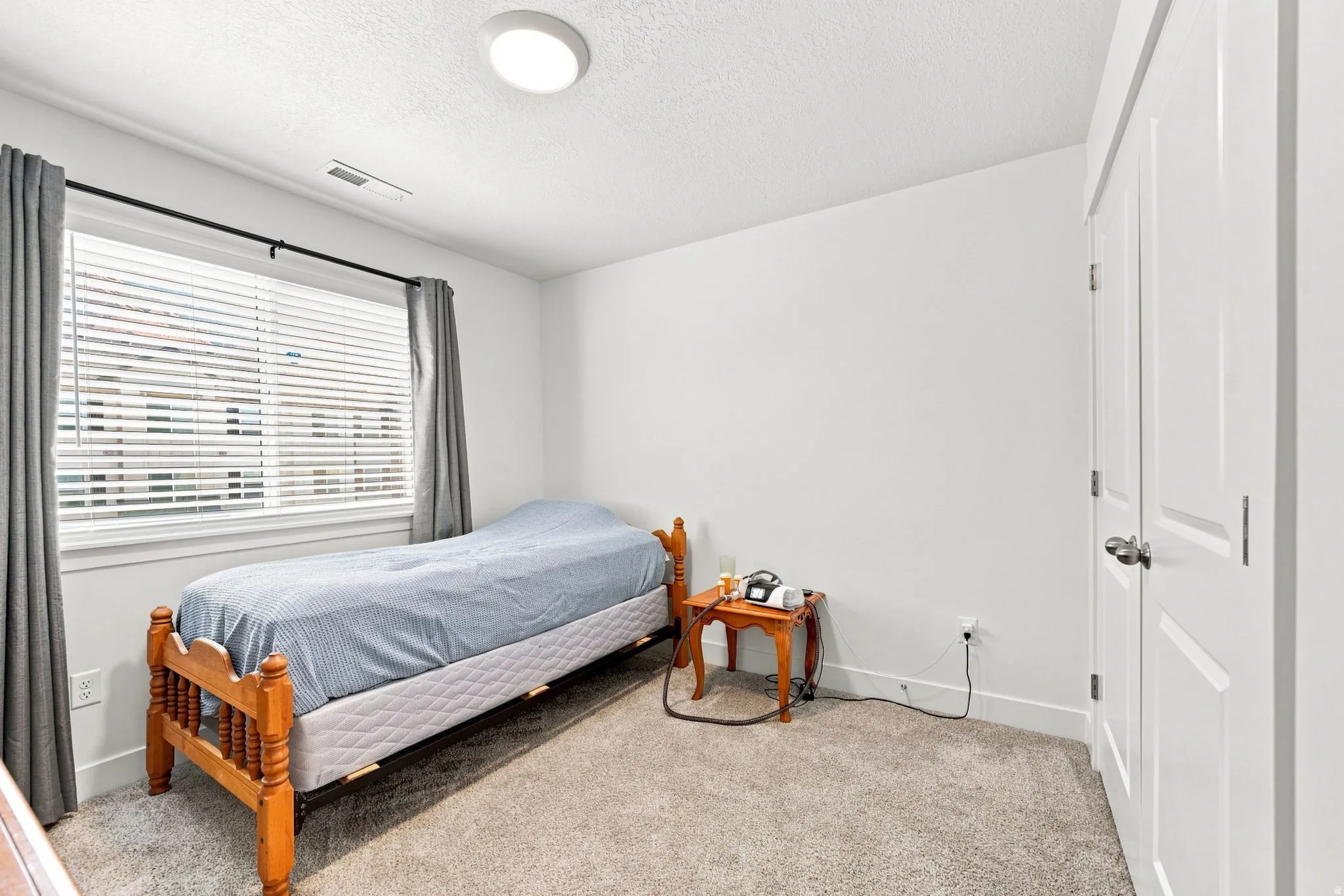 Carpeted room featuring a window with blinds, recessed lighting, and a bi-fold closet door