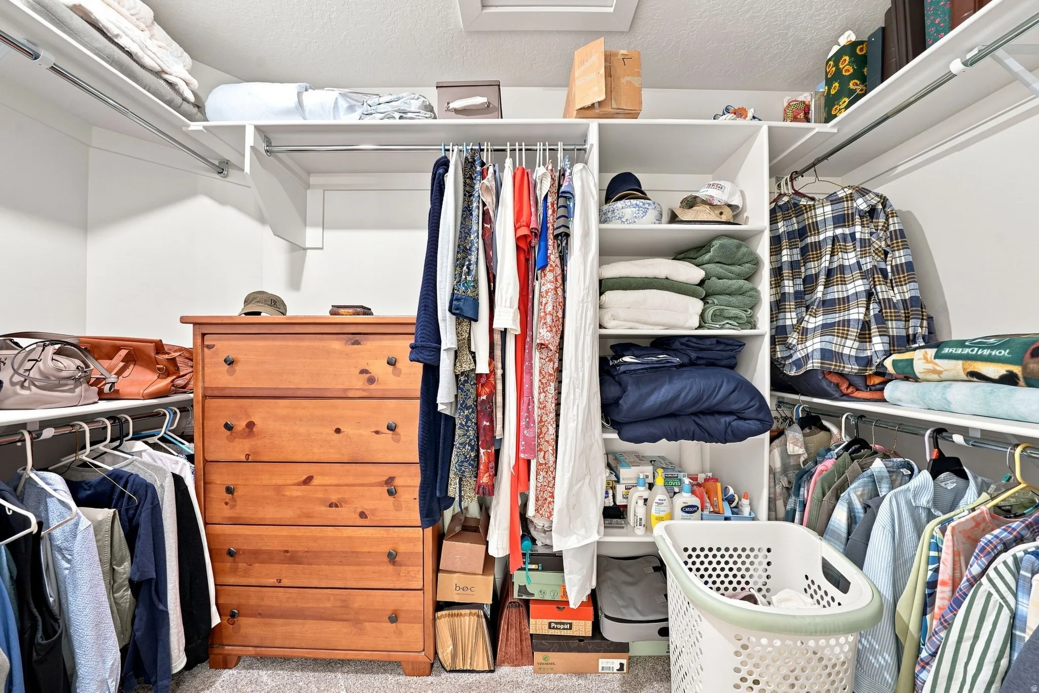 Integrated closet system featuring white shelving and hanging rods