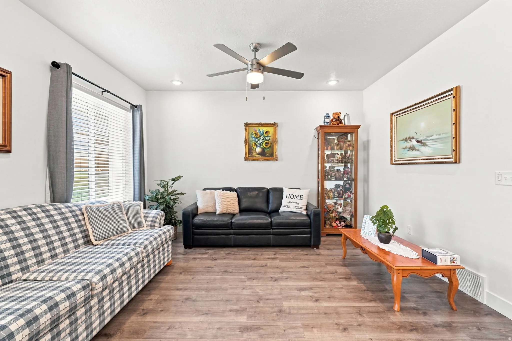 Vaulted ceiling with a ceiling fan and recessed lighting, wood-finish flooring throughout, and a window with blinds