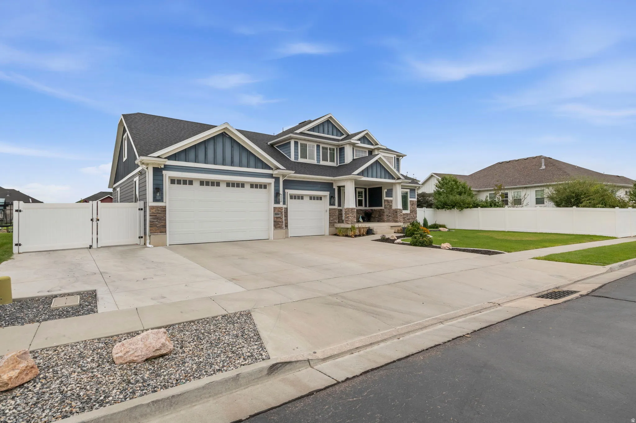 Two-story exterior with a three-car garage, stone accents, and a covered porch