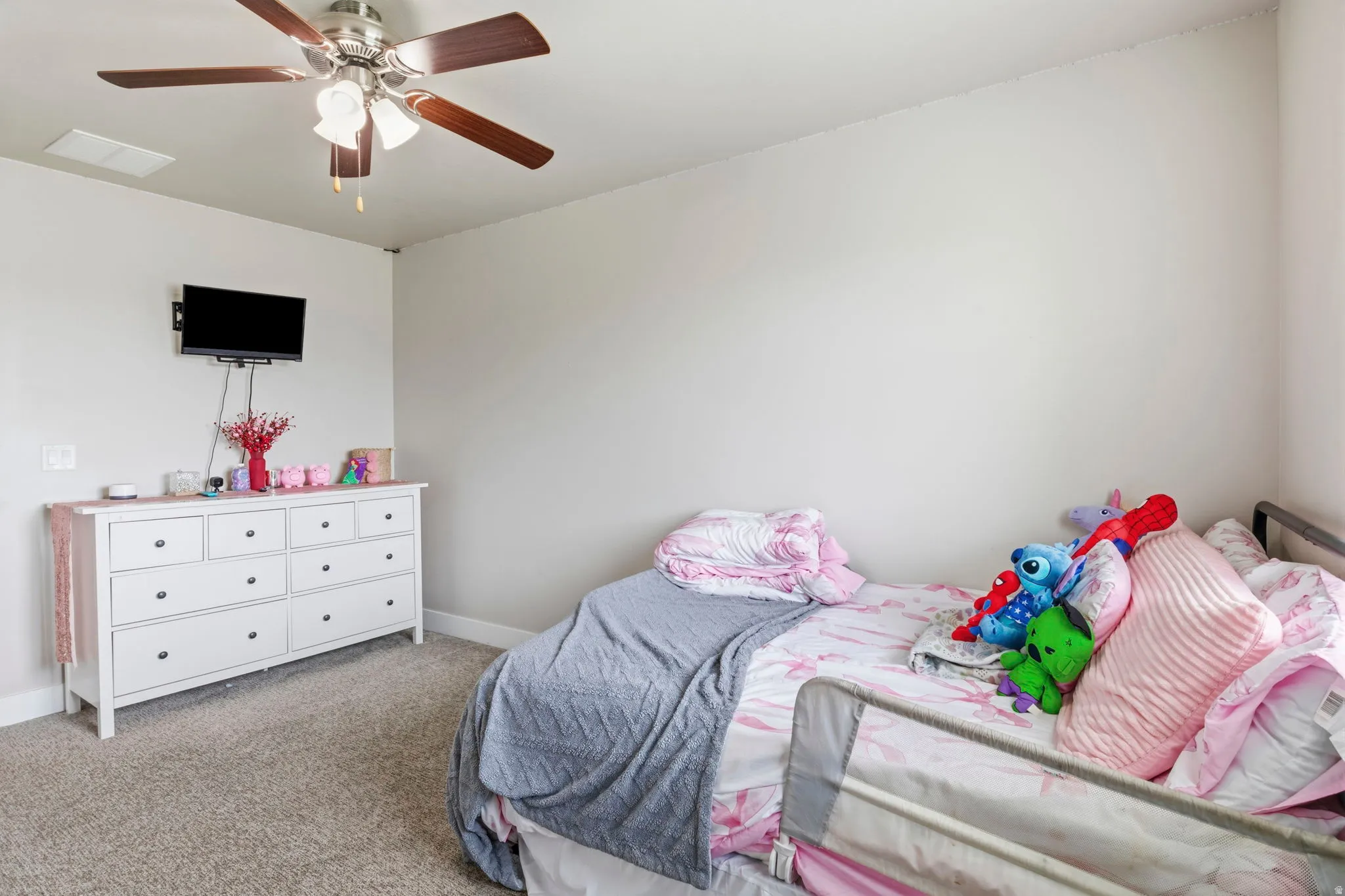 Ceiling fan with light fixture, wall-mounted television, and carpet flooring