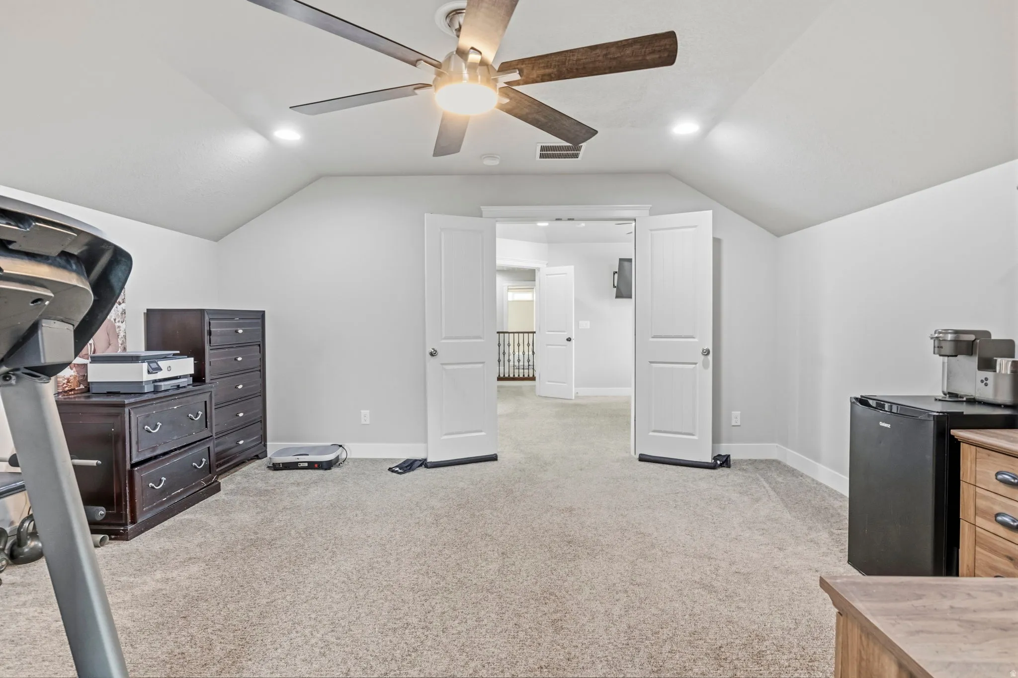 Angled ceiling lines with recessed lighting, ceiling fan with light, and carpeted flooring