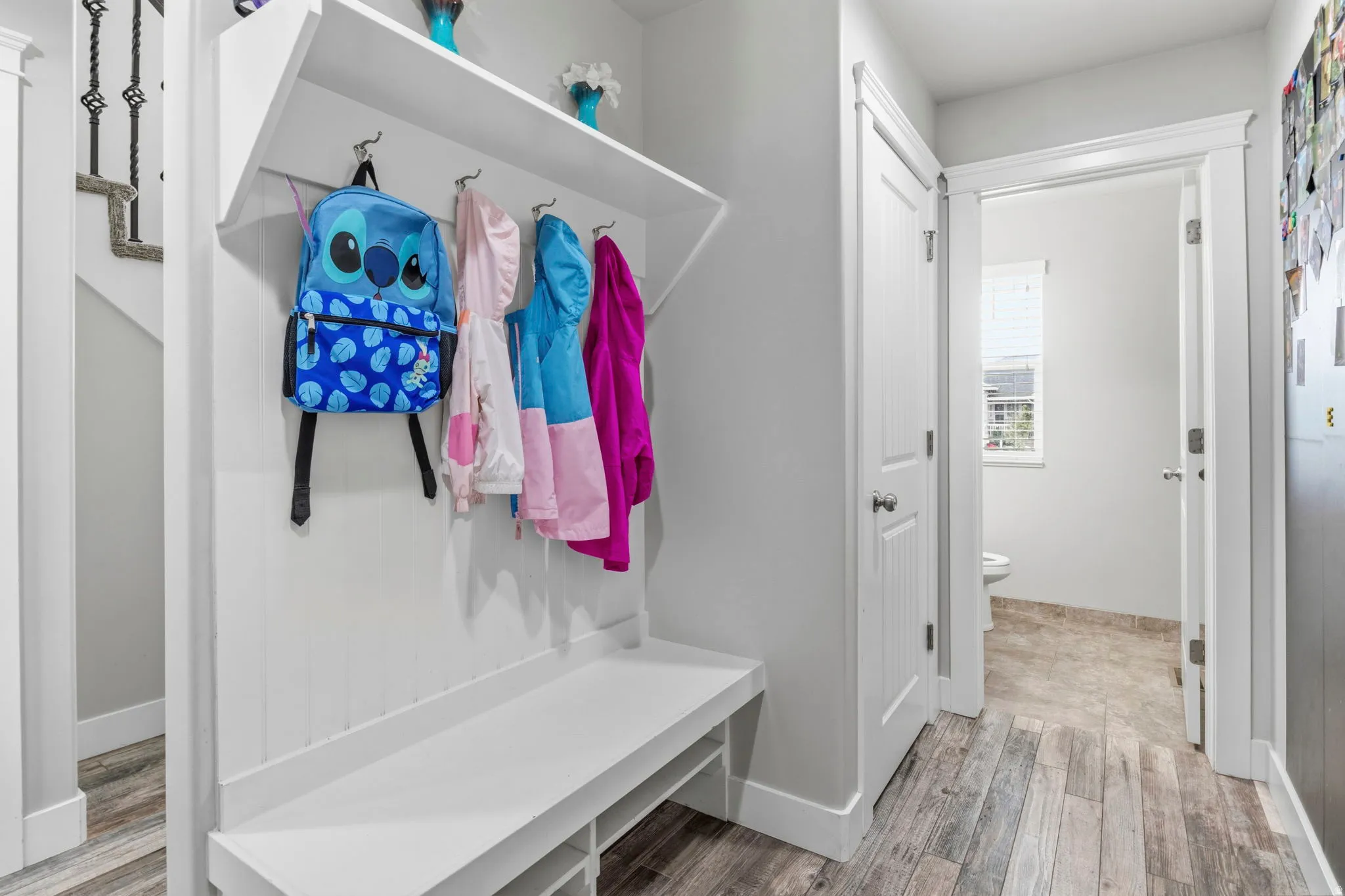 Built-in mudroom bench with coat hooks, overhead shelf, and storage cubbies