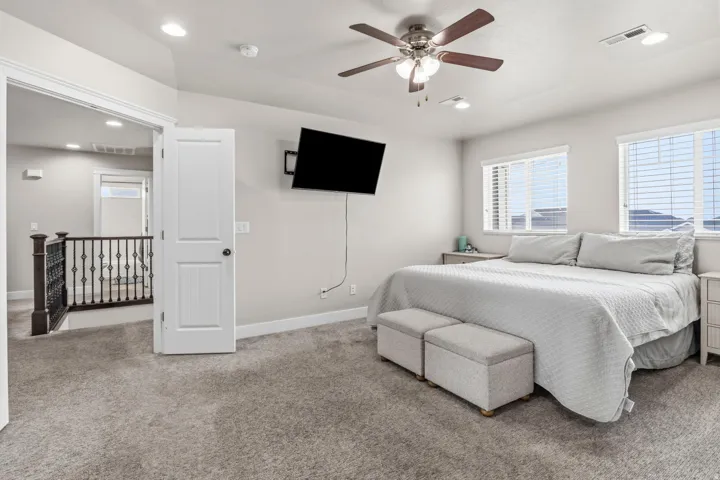 Plush carpet flooring, ceiling fan with integrated lighting, recessed lighting, white window blinds, and an iron baluster staircase