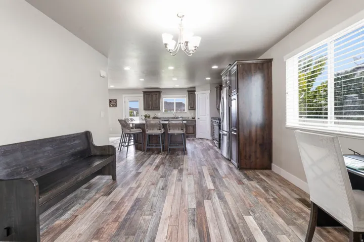Open-concept living area featuring wood-finish flooring, recessed lighting, and a kitchen island with built-in seating