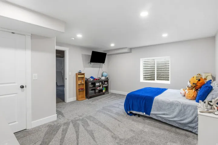 Recessed lighting, light gray wall paint, white trim, and gray carpeted flooring