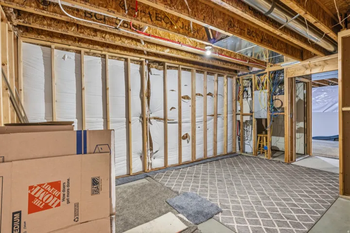 Unfinished room with exposed wood framing, ceiling joists, and visible insulation
