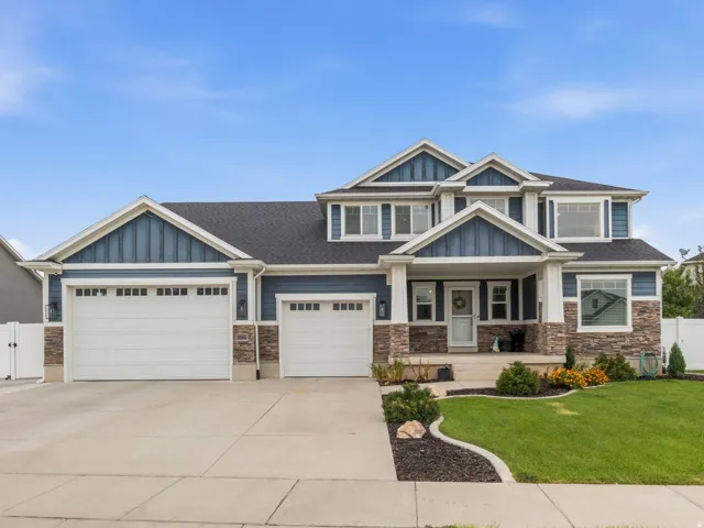 Two-story residence featuring blue siding, stone accents, and a covered front entry