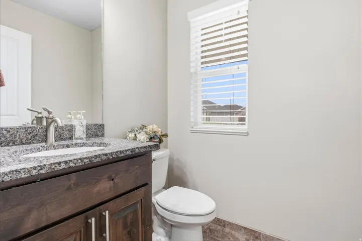 Wood-finish vanity with a stone countertop and an undermount sink