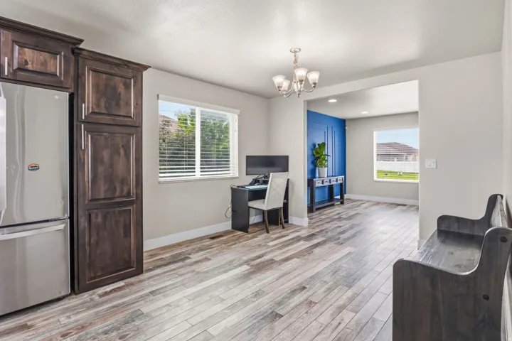 Wood-finish flooring throughout, with a built-in refrigerator and dark wood cabinetry