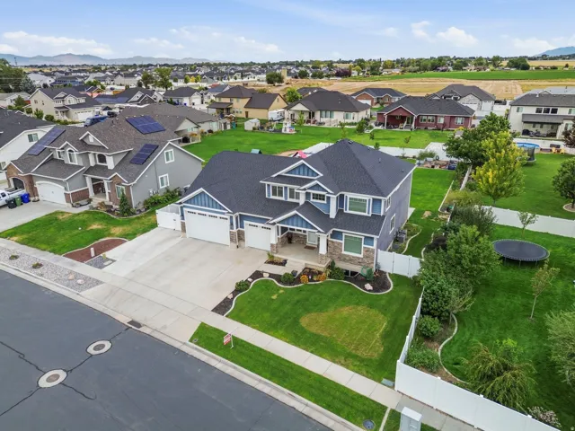 Two-story residence with a stone and siding exterior, multi-car garage, and a covered front entry