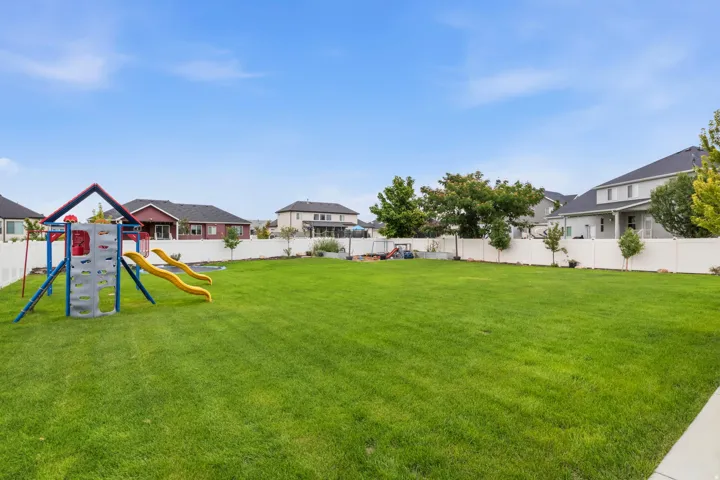 Expansive green lawn, white privacy fencing, and mature trees