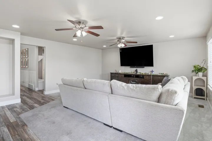 Recessed lighting with multiple ceiling fans and wood-finish flooring