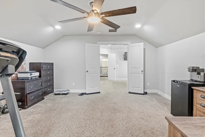 Angled ceiling lines with recessed lighting, ceiling fan with light, and carpeted flooring