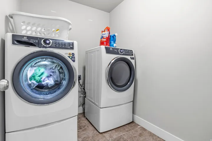 Laundry area featuring light-toned walls and tiled flooring