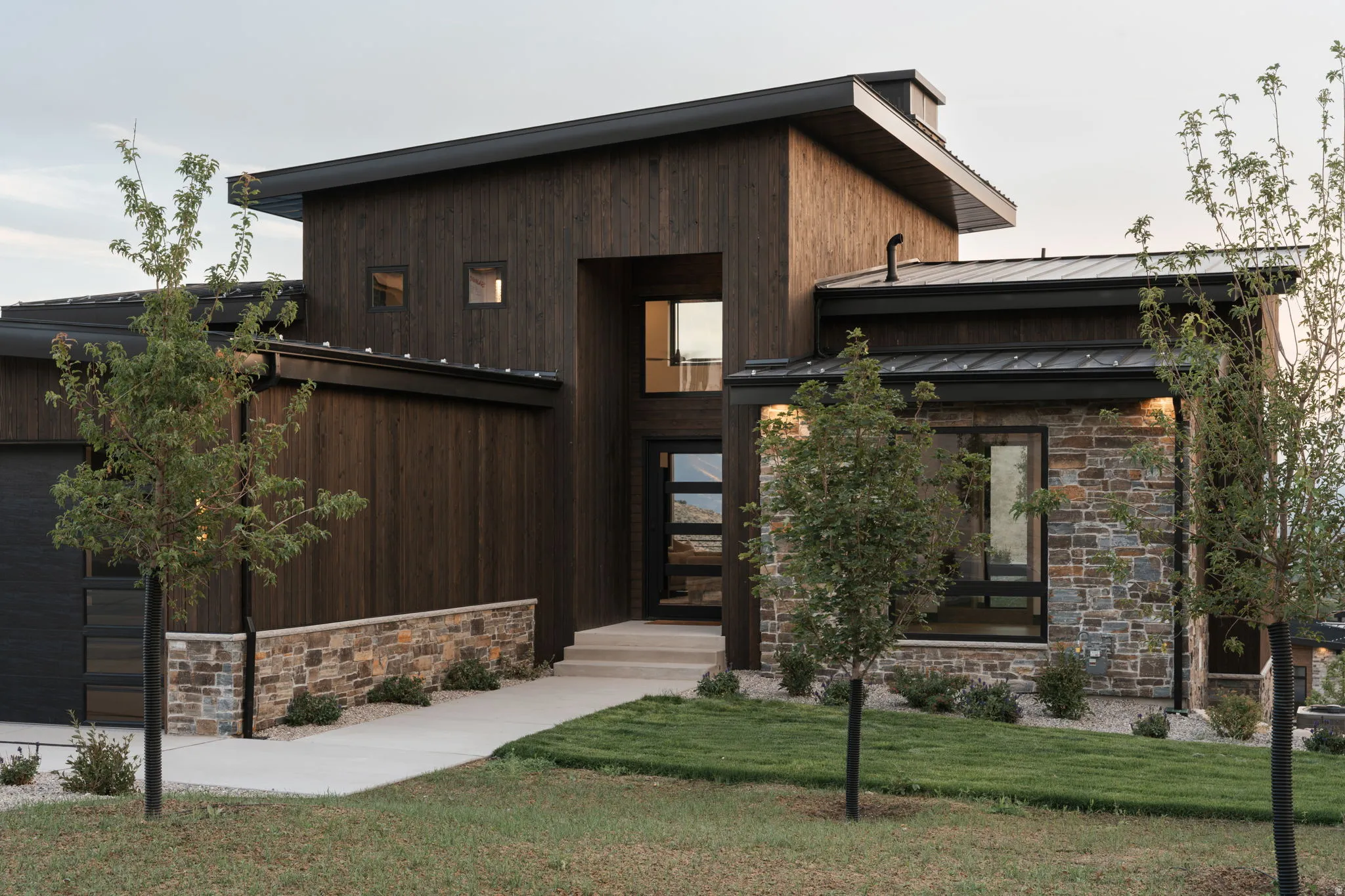 Contemporary exterior with dark wood-finish siding and natural stone accents