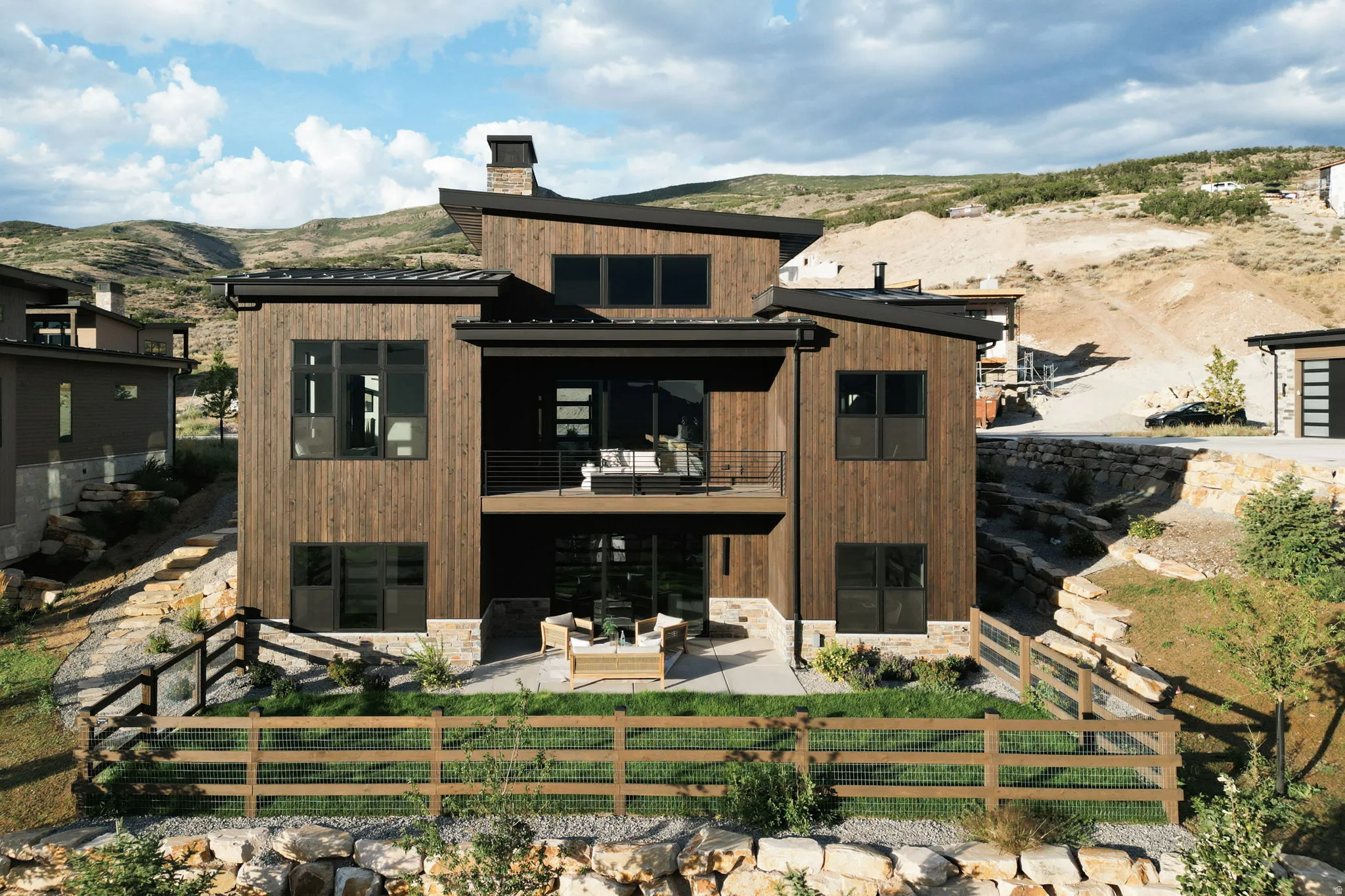 Modern architectural design featuring extensive wood paneling, multiple levels of outdoor living, and large windows