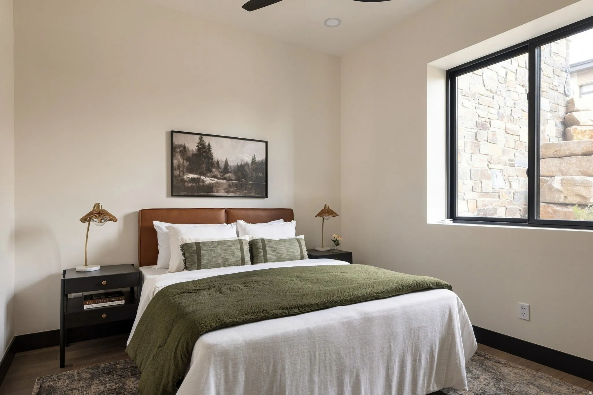 Recessed lighting, sloped ceiling, black-framed window, stone exterior wall, wood-finish flooring