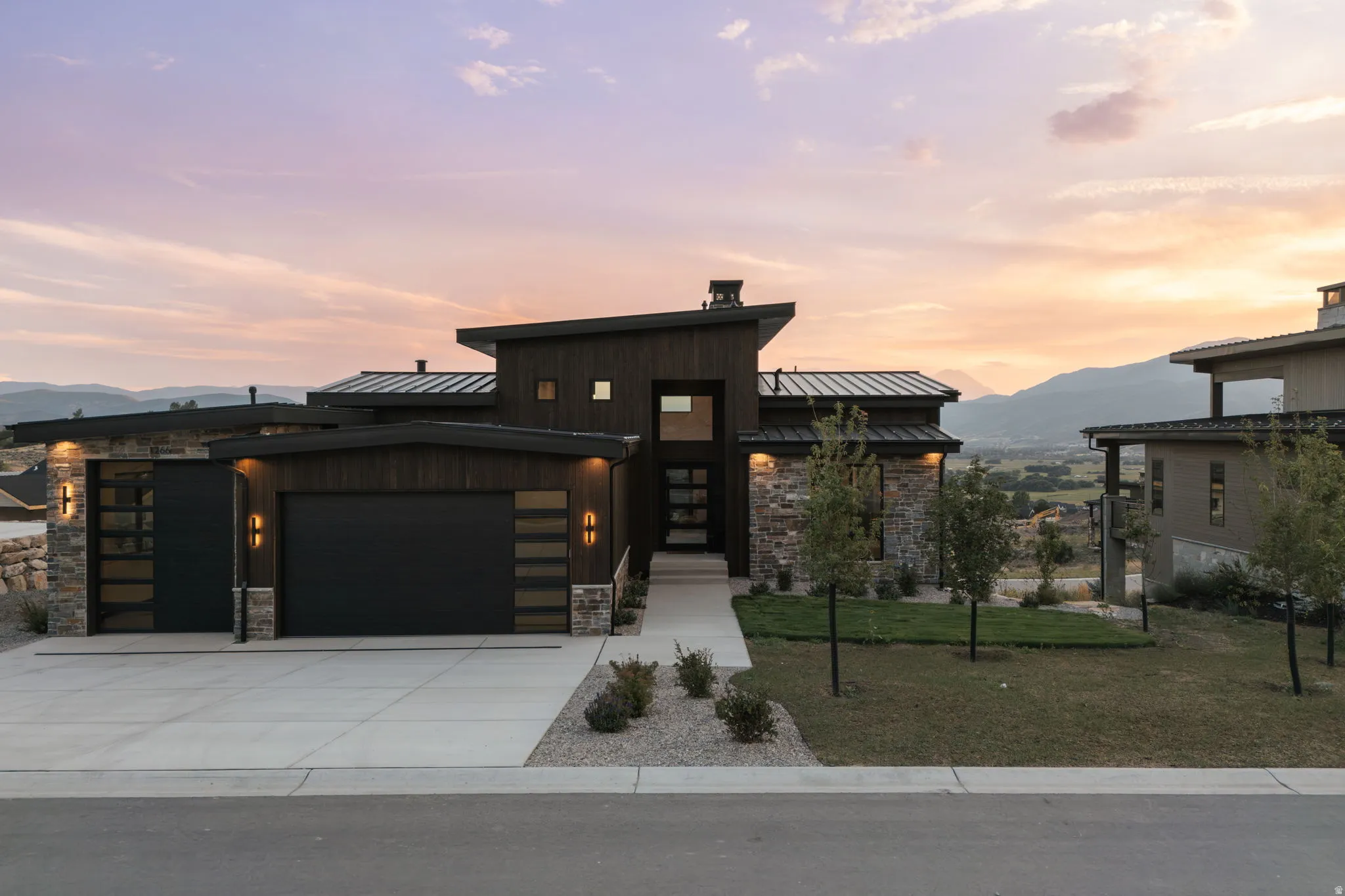 Contemporary architectural design featuring dark wood siding and stone accents