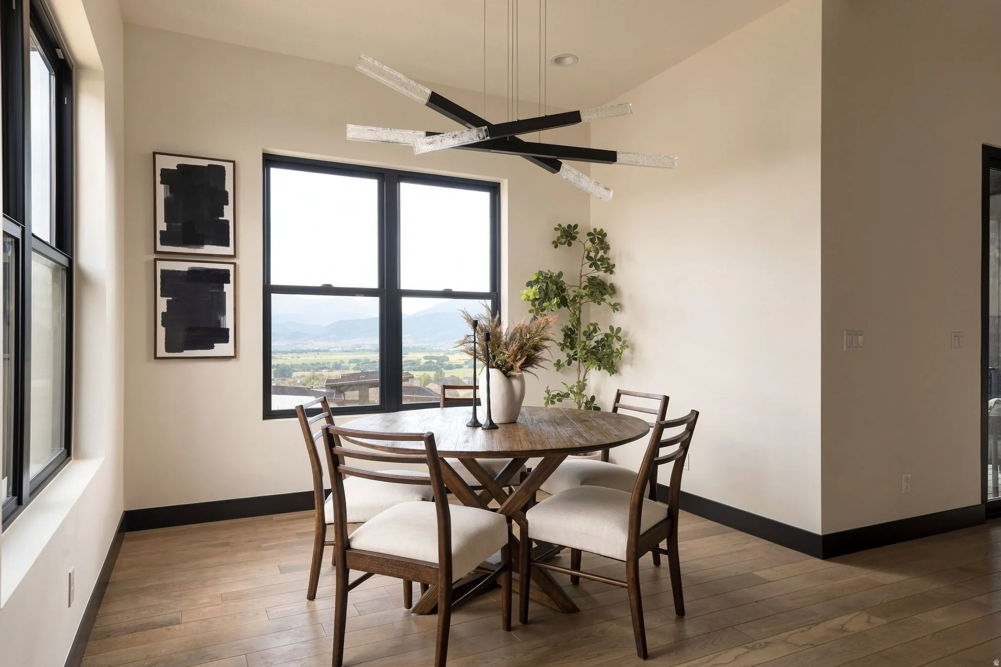 Expansive windows, wood-finish flooring, contemporary chandelier, and recessed lighting