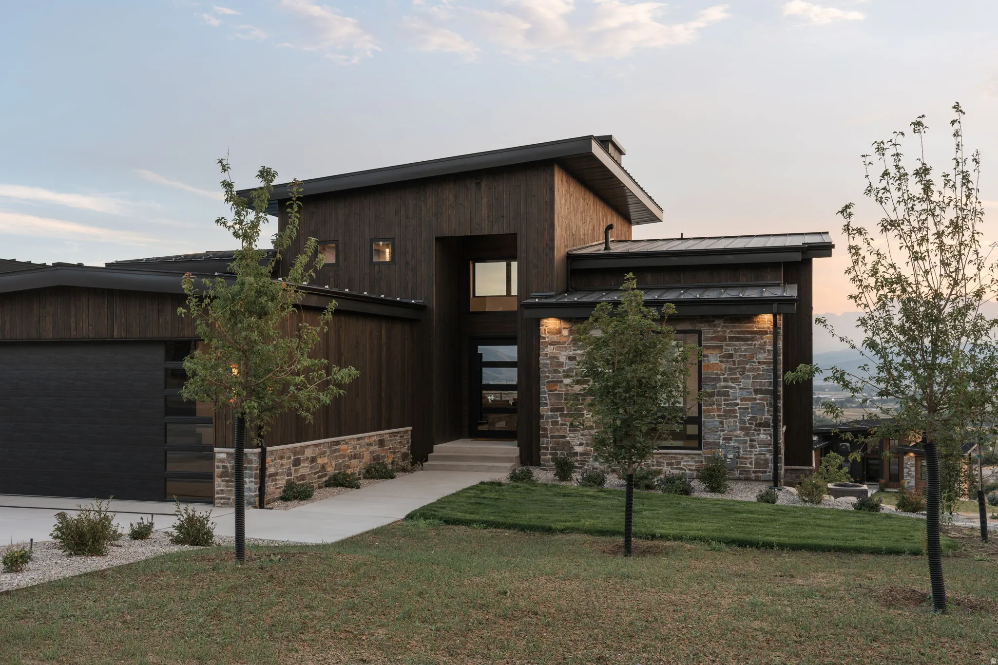 Modern architectural design with dark wood siding and stone accents