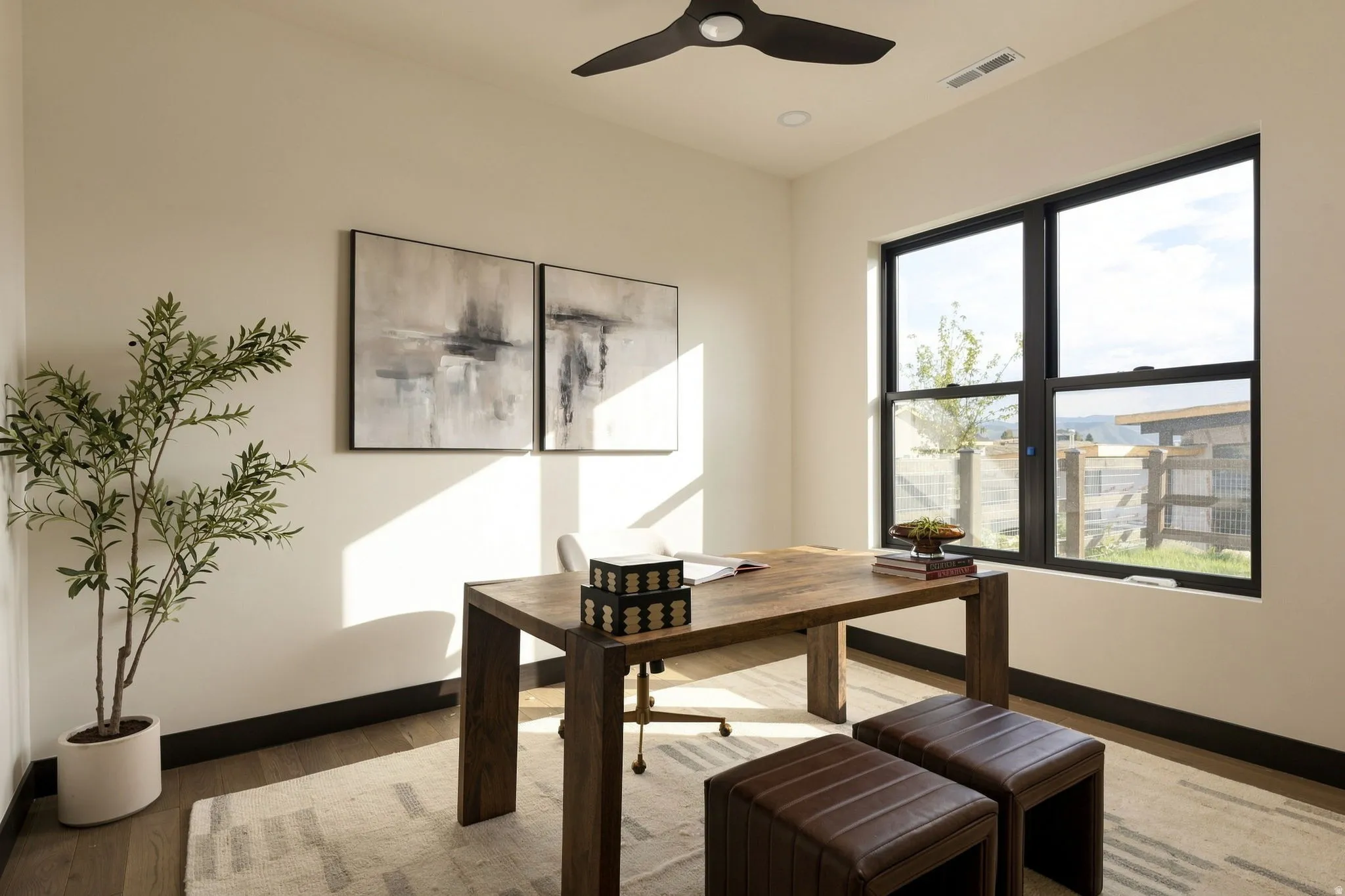 Wood-finish flooring, white walls, and dark window trim