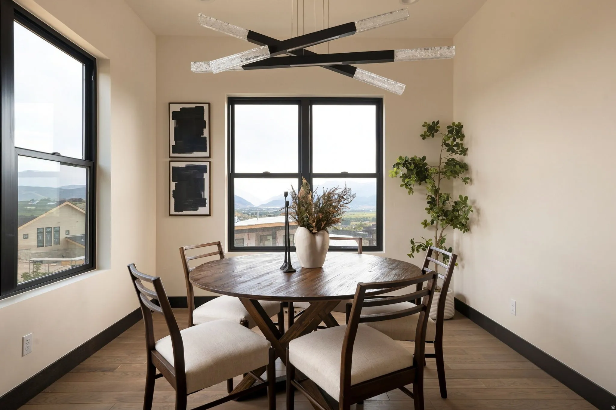 Multi-pane windows, wood-finish flooring, and a modern linear chandelier