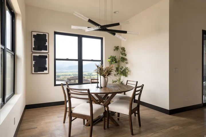 Expansive windows, wood-finish flooring, contemporary chandelier, and recessed lighting