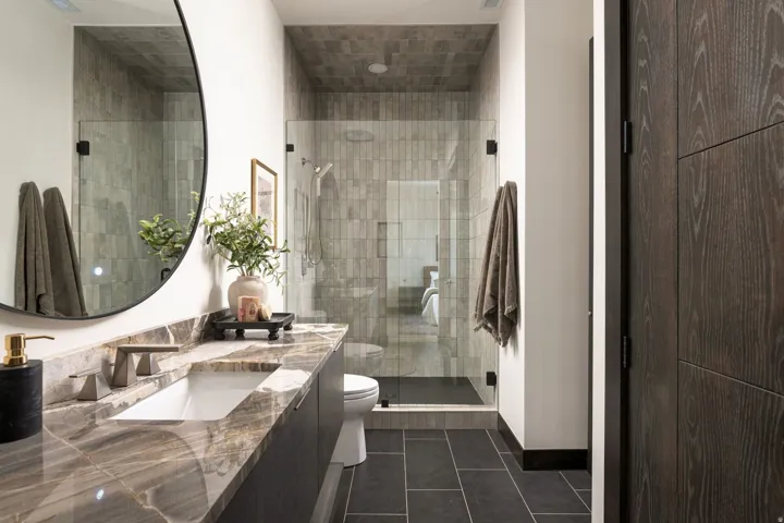 Vanity with a rectangular undermount sink, a bronze-finish faucet, and a stone countertop