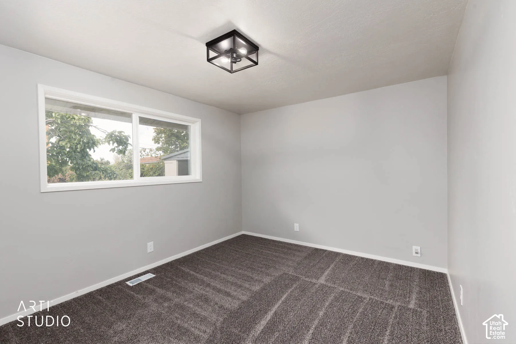 Neutral tone walls, plush carpet flooring, white trim, and a modern flush-mount light fixture